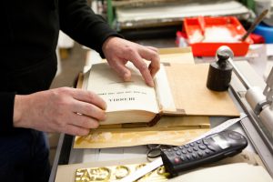bookbinder in his workshop restores an antique book